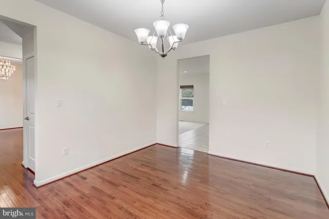 a view of a big room with wooden floor and a chandelier