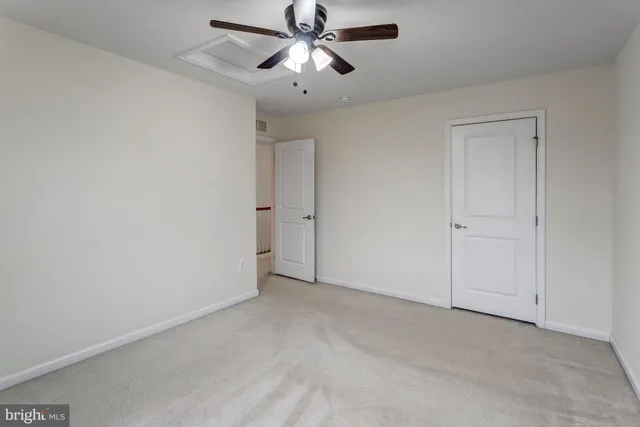 an empty room with chandelier fan
