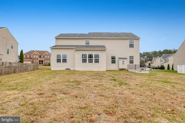 a view of a house with backyard and wooden fence