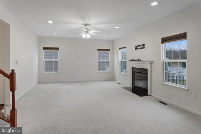 a view of an empty room with a fireplace and a window