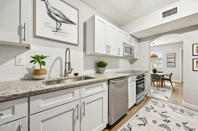 a kitchen with stainless steel appliances granite countertop a sink stove and cabinets