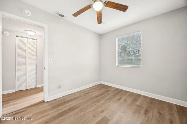 a view of empty room with wooden floor