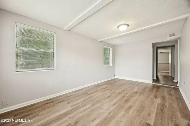 wooden floor in an empty room with a window