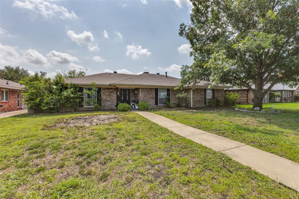 705 South Grove Road Richardson, TX 75081 - Photo 2 of 26 Single-story brick exterior featuring a dark front door, multiple windows with dark shutters, and a sloped roofline