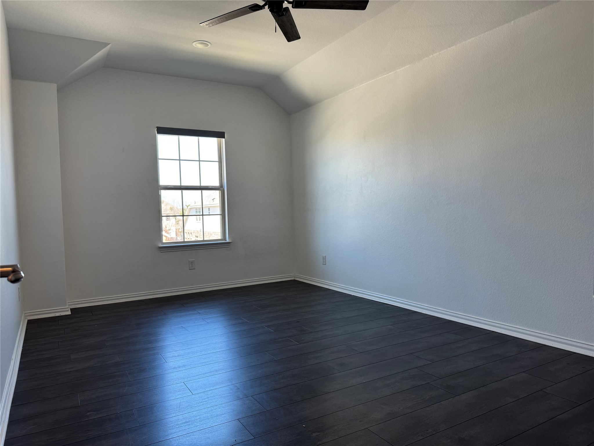 623 Pheasant Hill Lane Georgetown, TX 78628 - Photo 11 of 17 Unfurnished room featuring dark wood-type flooring, vaulted ceiling, and a ceiling fan