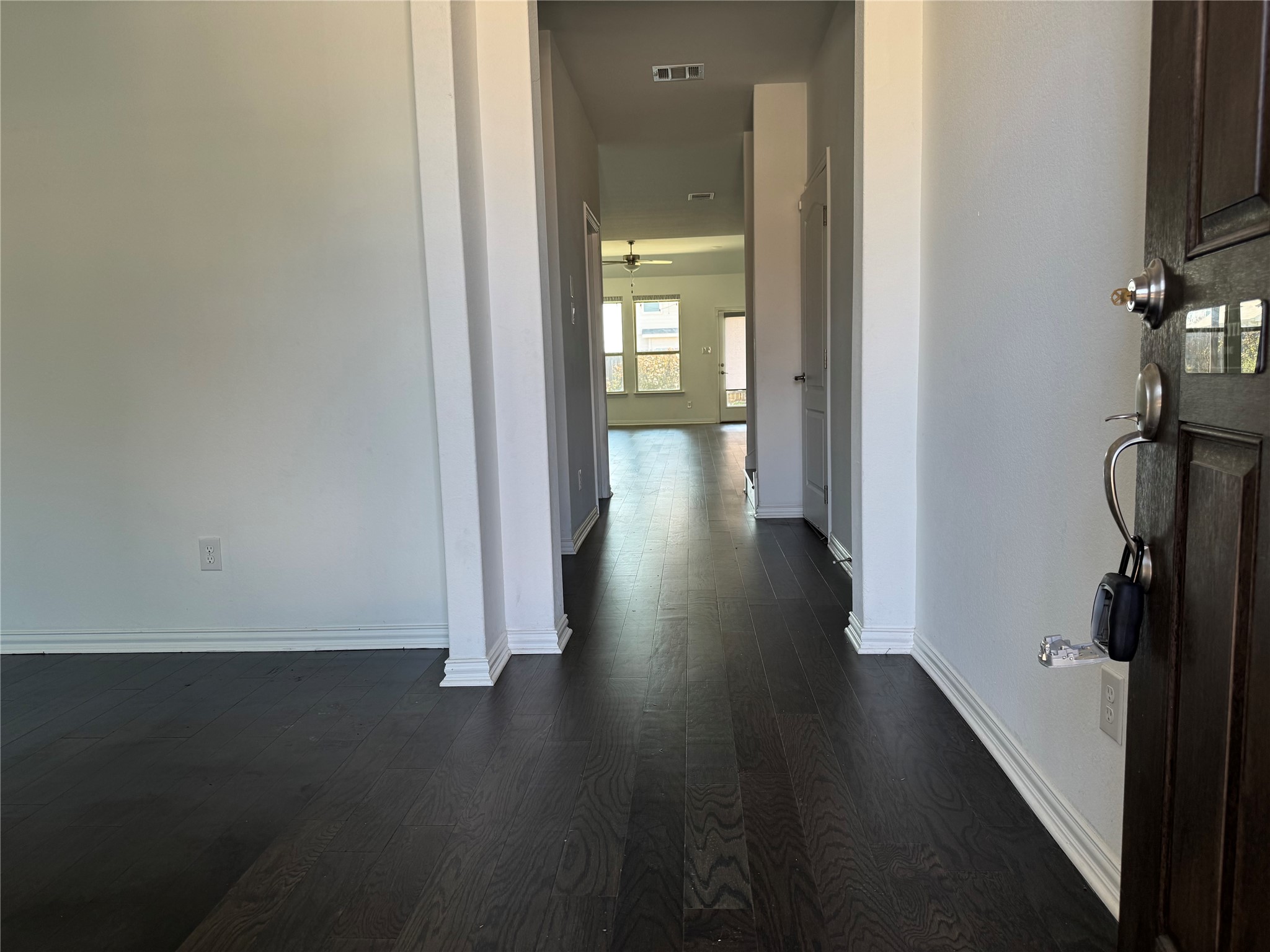623 Pheasant Hill Lane Georgetown, TX 78628 - Photo 4 of 17 Hallway featuring dark wood-style flooring and baseboards