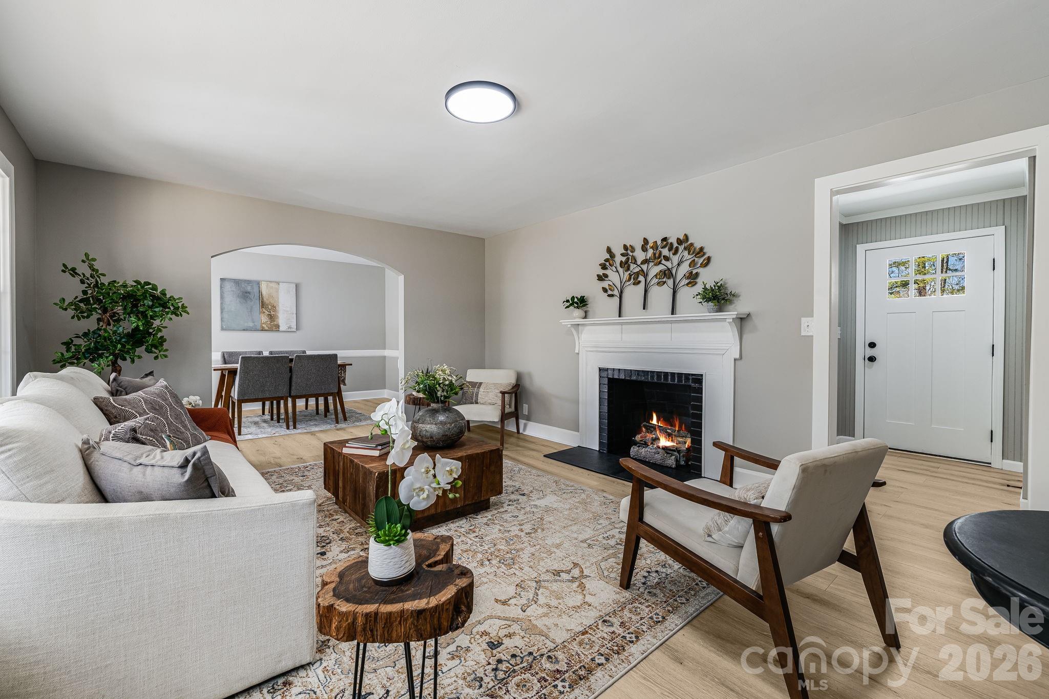 107 Balsam Road Hendersonville, NC 28792 - Photo 18 of 44 a living room with furniture a fireplace and a potted plant