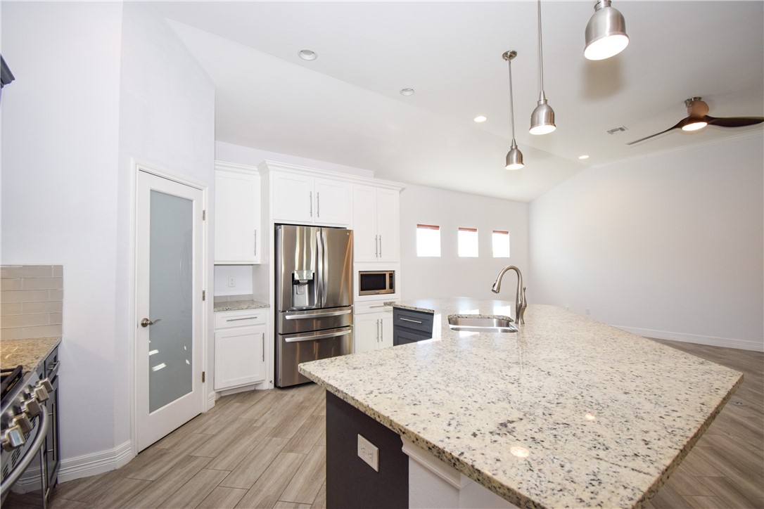 16026 Cuttysark Street Corpus Christi, TX 78418 - Photo 12 of 37 a kitchen with stainless steel appliances granite countertop a sink refrigerator and microwave