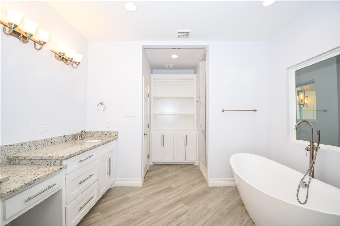 16026 Cuttysark Street Corpus Christi, TX 78418 - Photo 18 of 37 a spacious bathroom with a granite countertop sink and a mirror