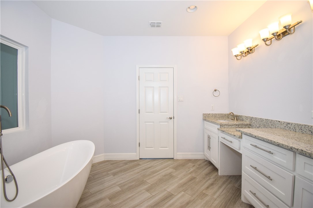16026 Cuttysark Street Corpus Christi, TX 78418 - Photo 21 of 37 a view of a kitchen with white cabinets and wooden floor