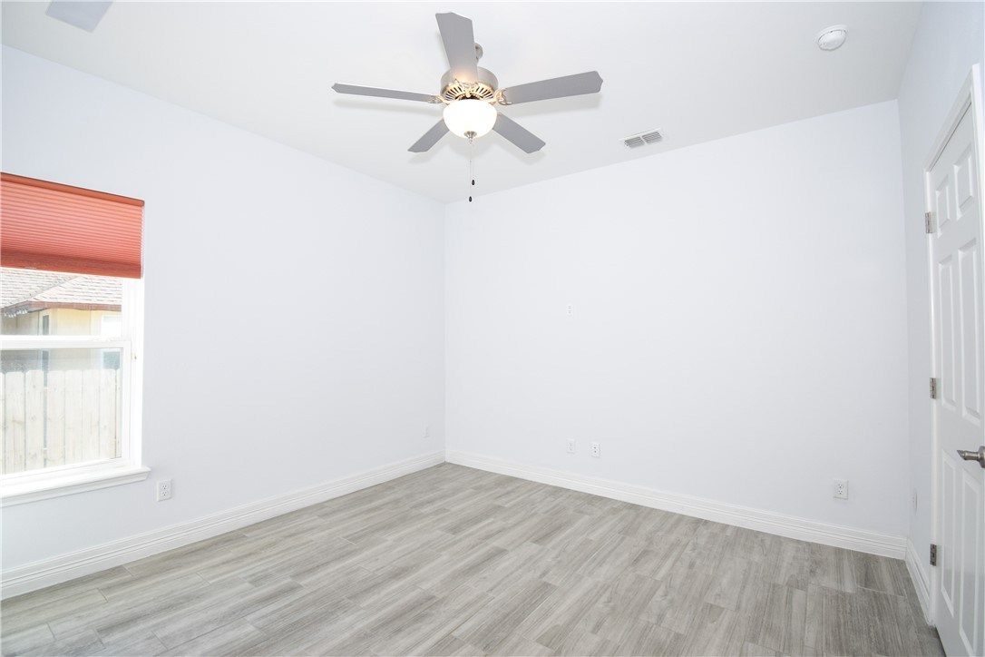16026 Cuttysark Street Corpus Christi, TX 78418 - Photo 26 of 37 an empty room with wooden floor fan and windows