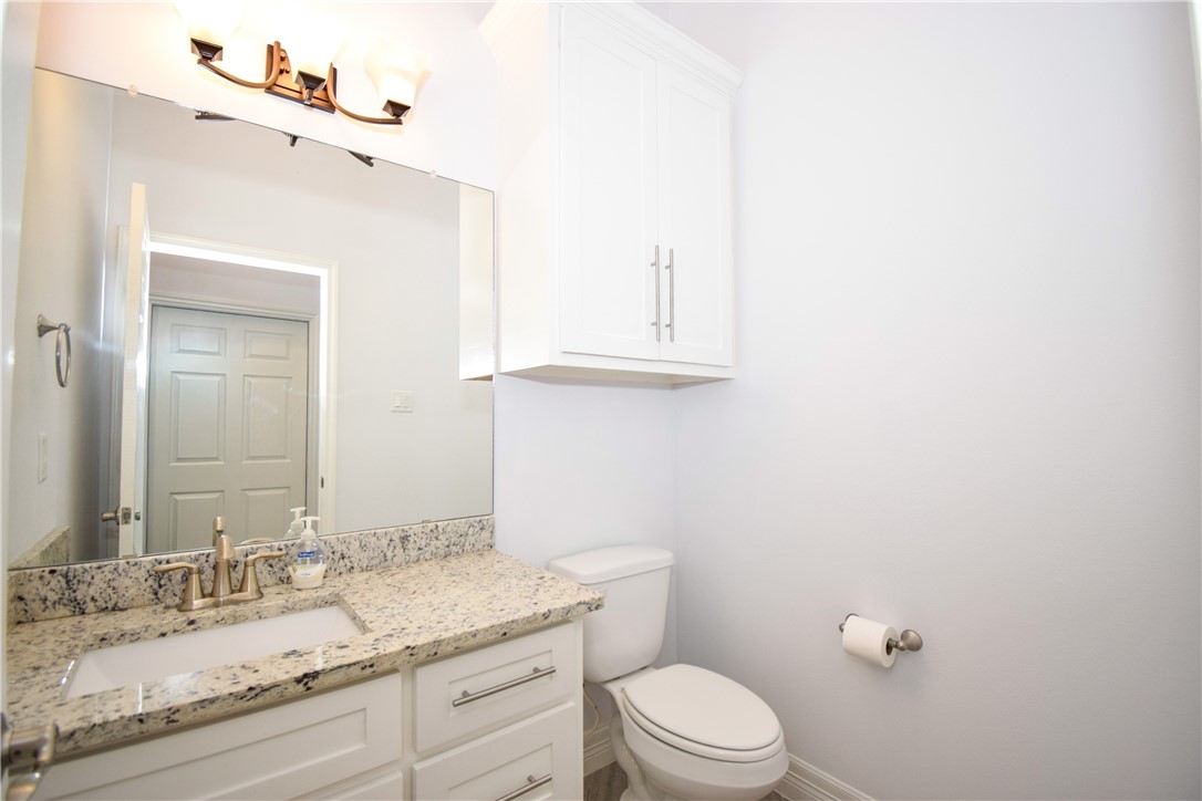 16026 Cuttysark Street Corpus Christi, TX 78418 - Photo 29 of 37 a bathroom with a granite countertop toilet sink mirror and vanity