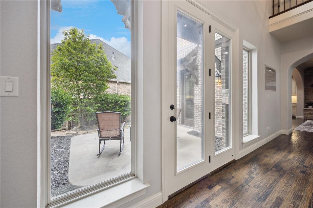 580 Butchart Drive Prosper, TX 75078 - Photo 15 of 40 Doorway with arched walkways, dark wood-style flooring, plenty of natural light, and baseboards