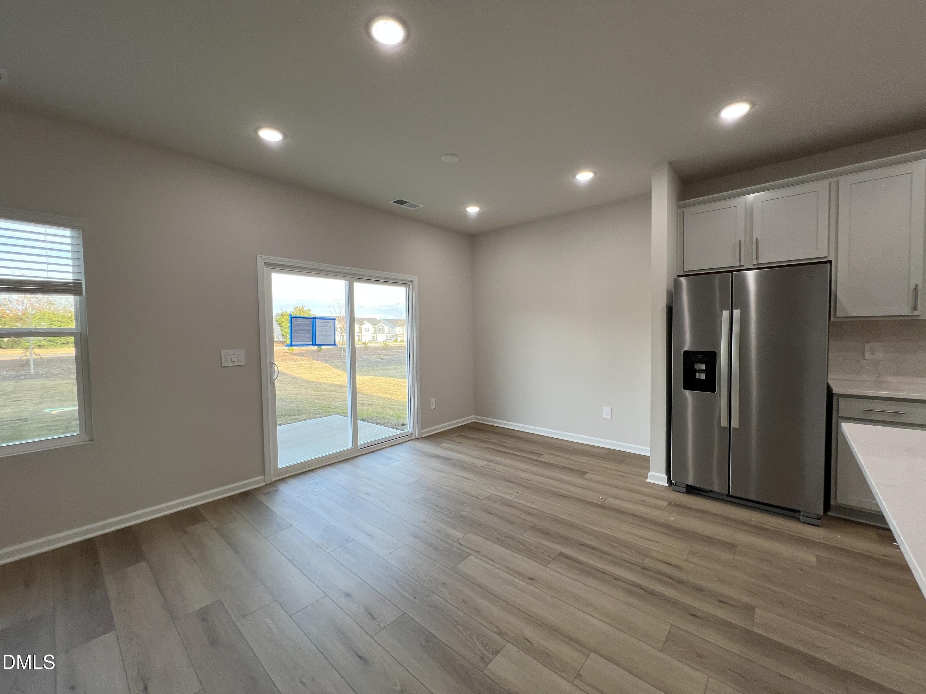 212 Thistle Patch Place Angier, NC 27501 - Photo 10 of 32 a view of an empty room with wooden floor and a window