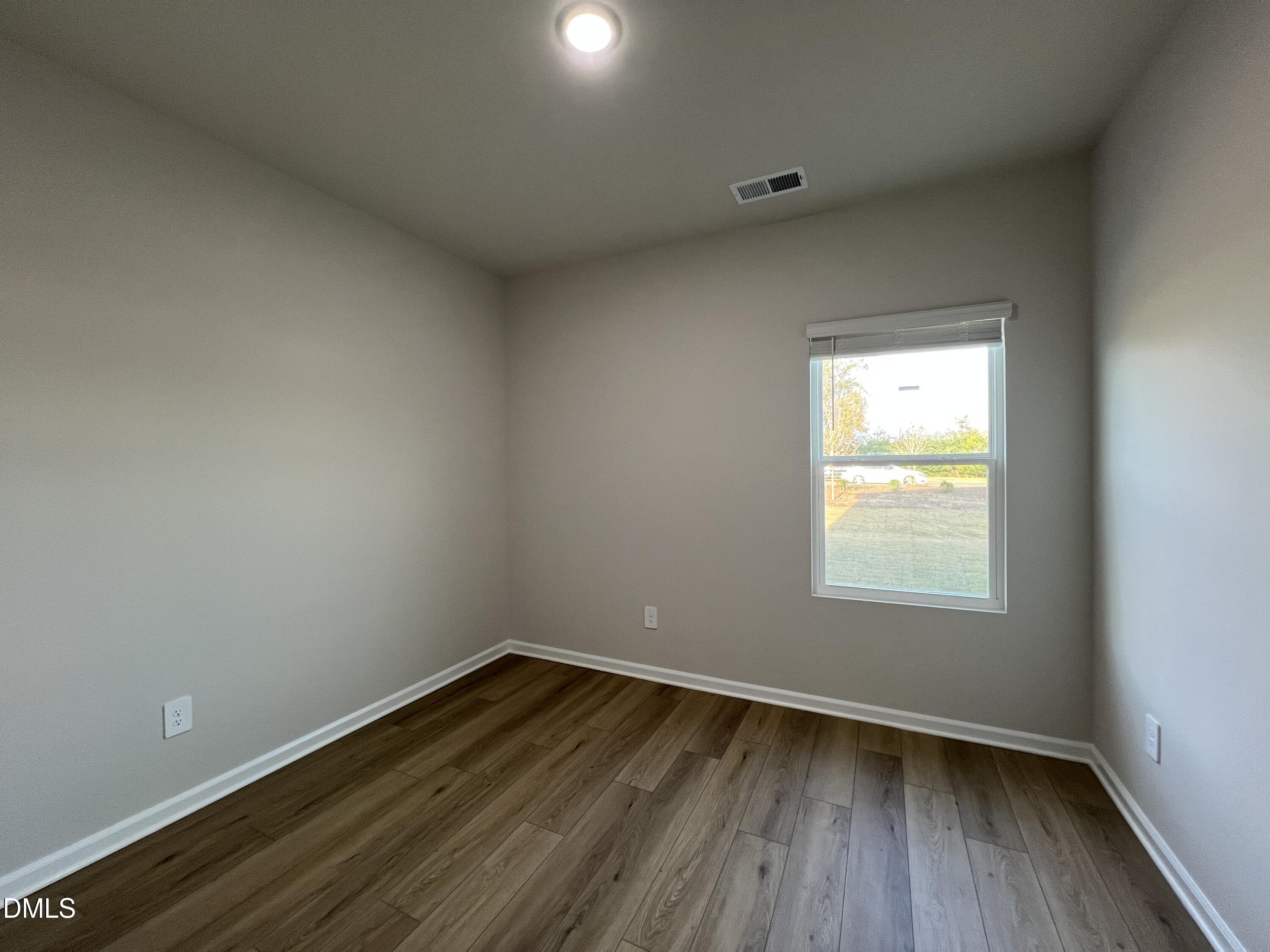 212 Thistle Patch Place Angier, NC 27501 - Photo 11 of 32 a view of an empty room and wooden floor and window
