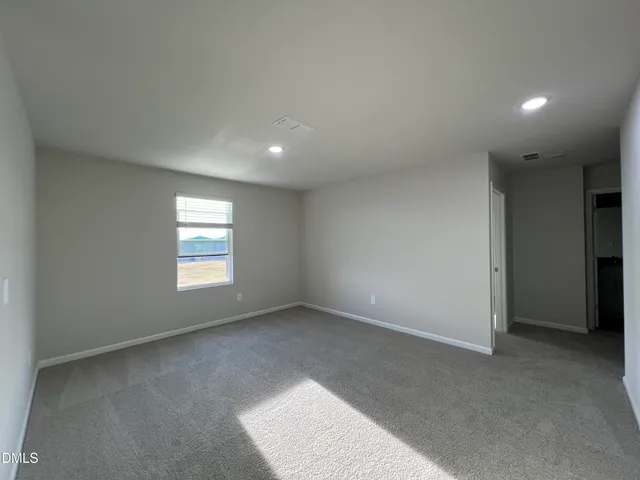 a view of an empty room and wooden floor and window