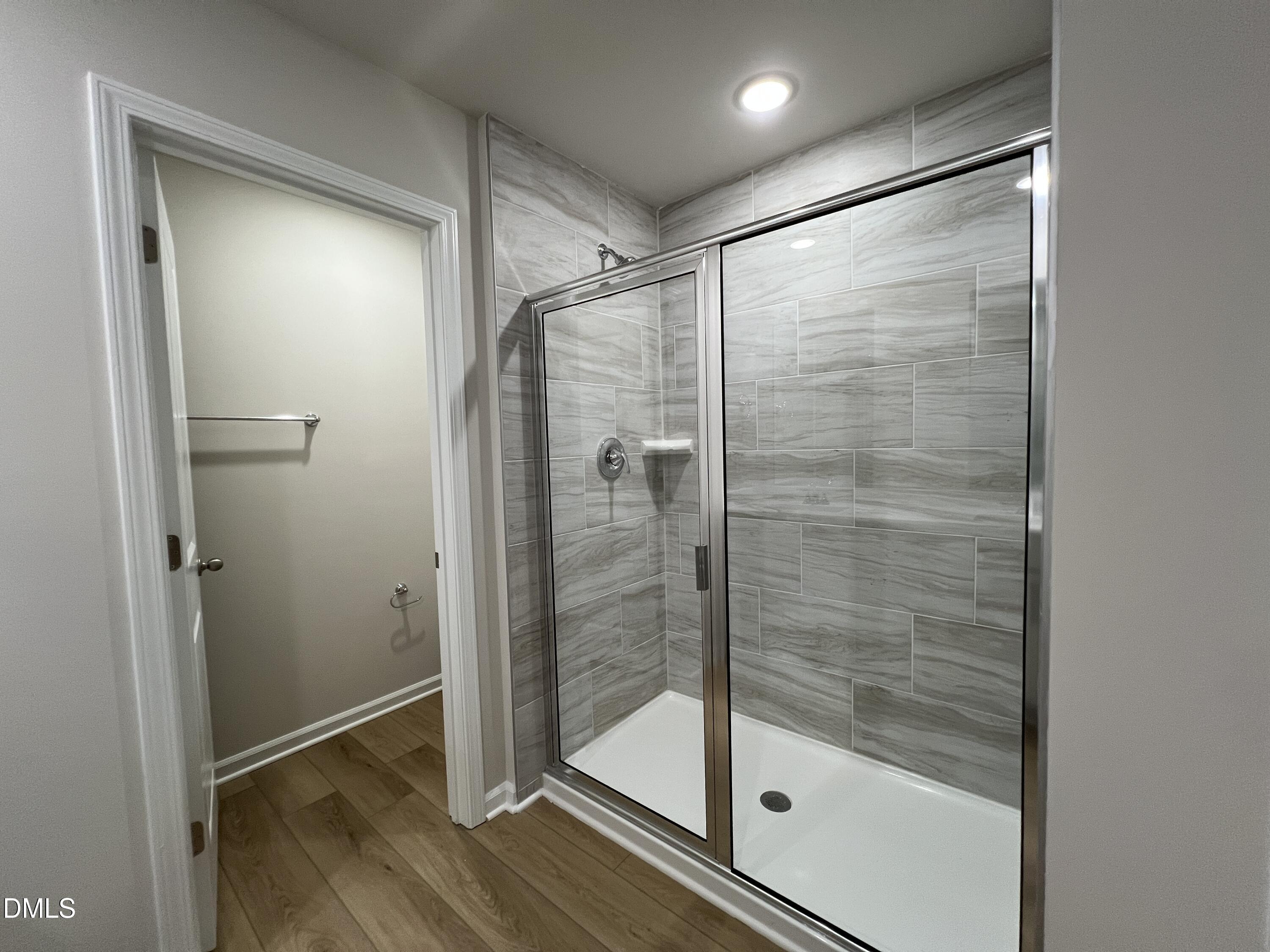 212 Thistle Patch Place Angier, NC 27501 - Photo 18 of 32 a bathroom with a glass shower door
