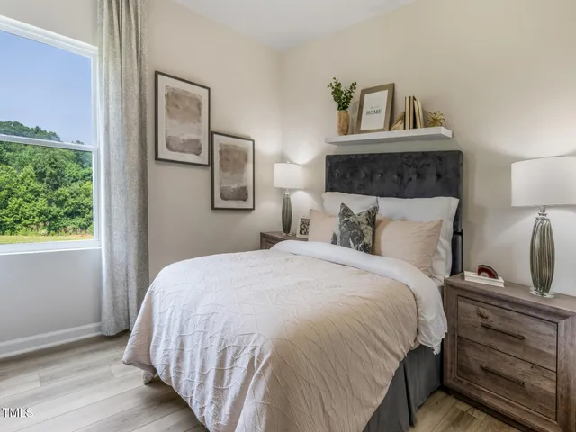 a bedroom with a bed and a potted plant