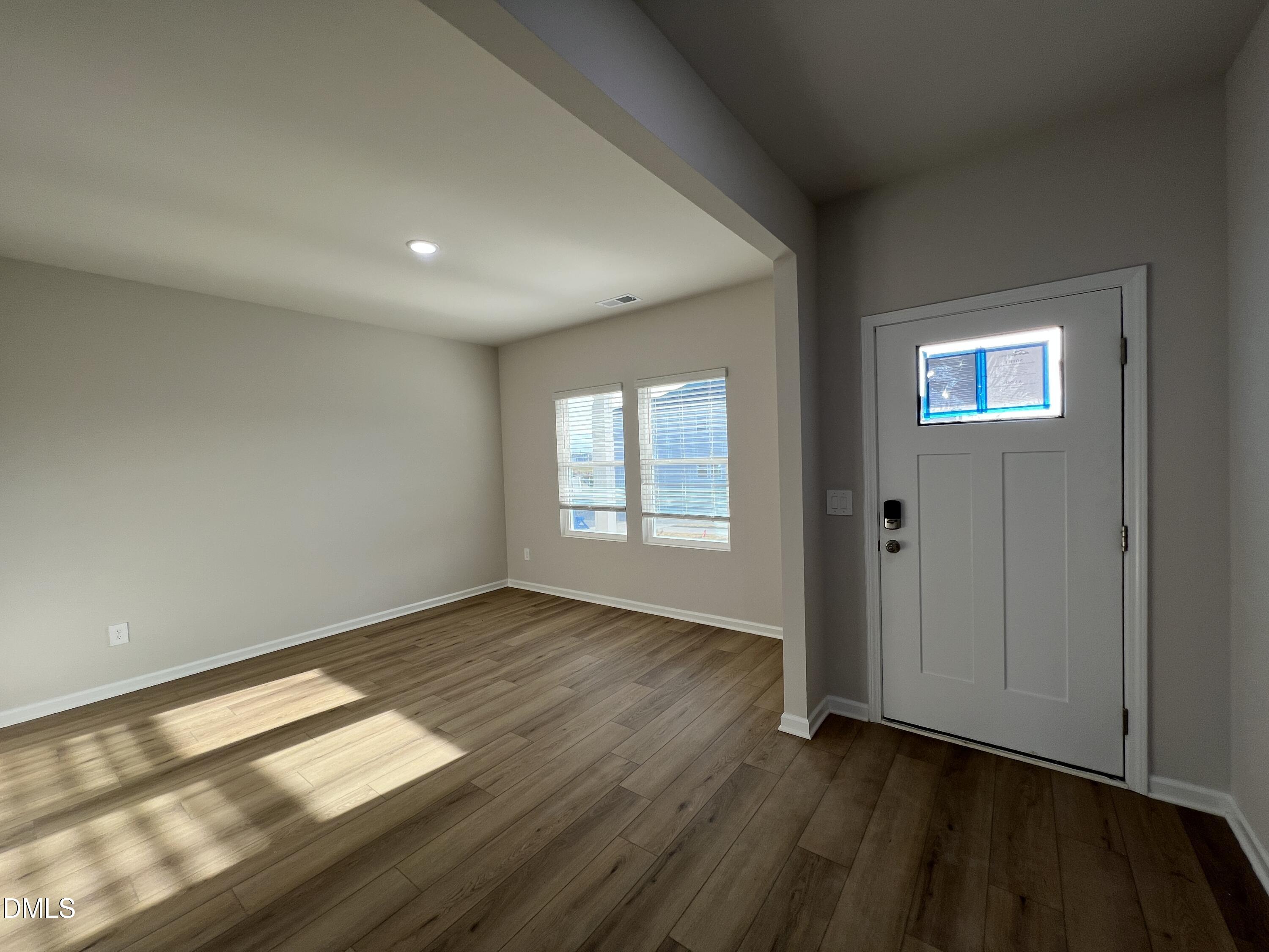212 Thistle Patch Place Angier, NC 27501 - Photo 3 of 32 an empty room with wooden floor and windows