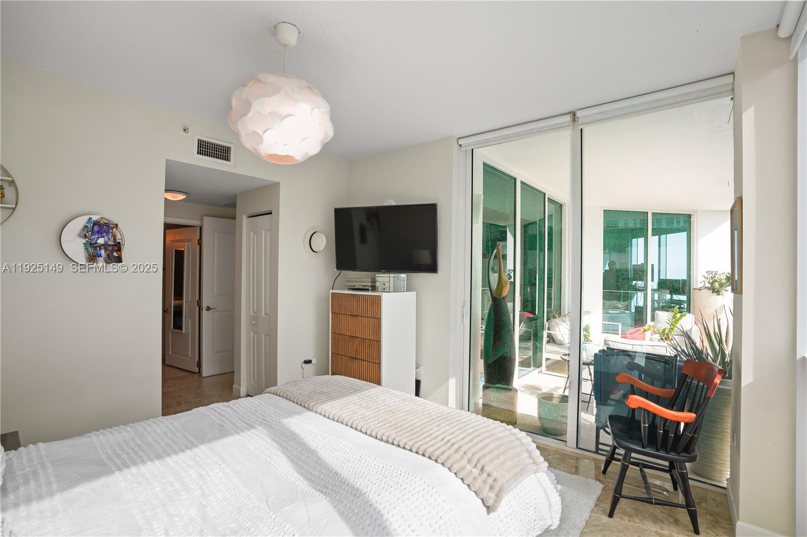 480 Northeast 30th Street, Unit 703 Miami, FL 33137 - Photo 14 of 31 a bedroom with a bed and a flat screen tv