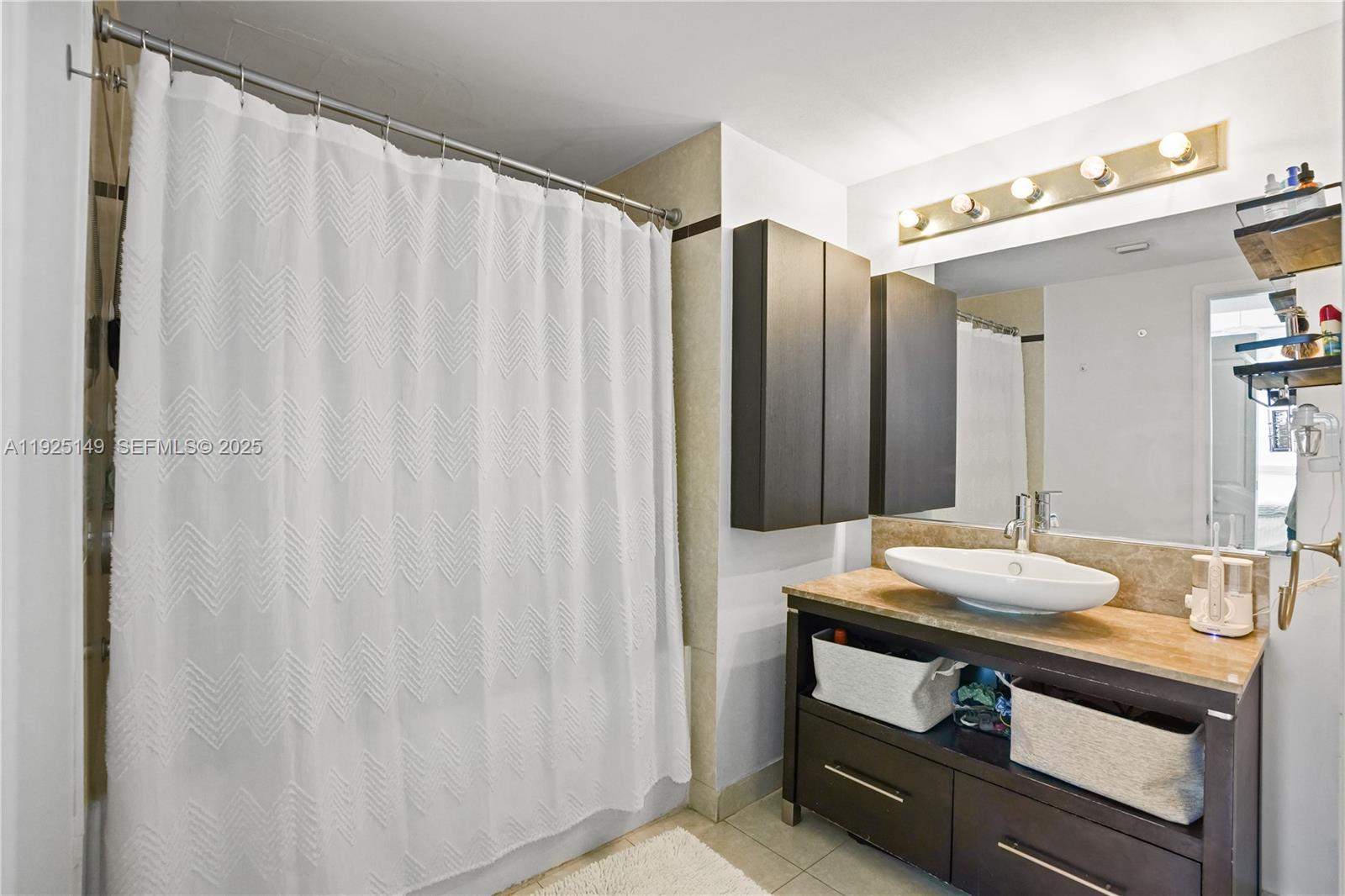 480 Northeast 30th Street, Unit 703 Miami, FL 33137 - Photo 17 of 31 a bathroom with a sink and a mirror