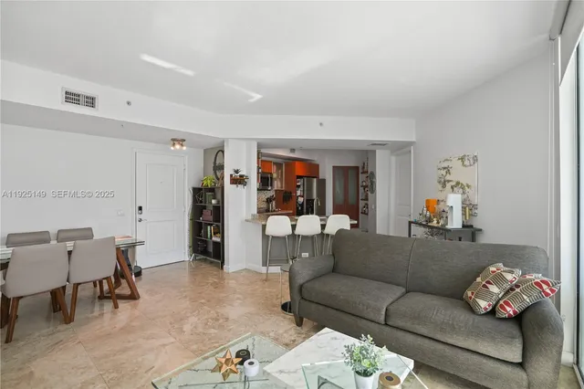 a living room with furniture and a dining table with kitchen view
