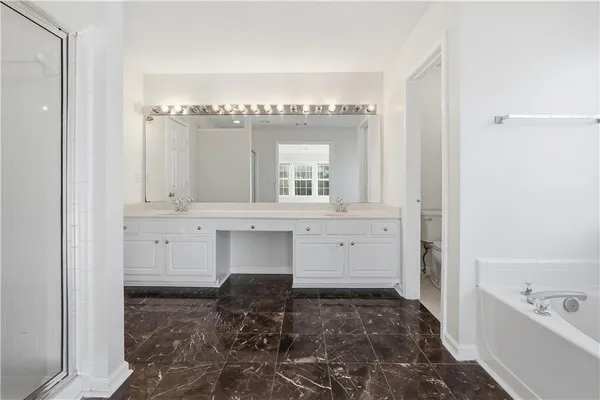 a bathroom with a bathtub sink and mirror