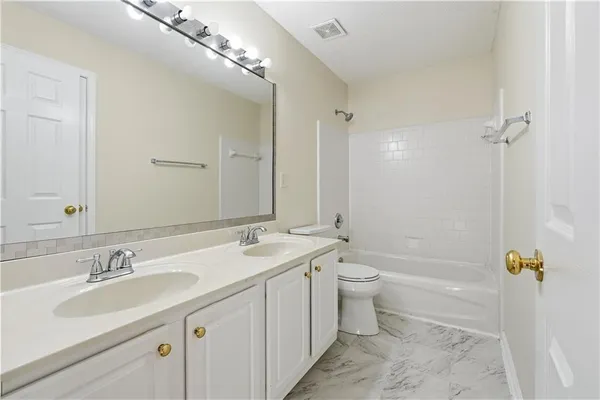 a bathroom with a double vanity sink toilet mirror and bathtub