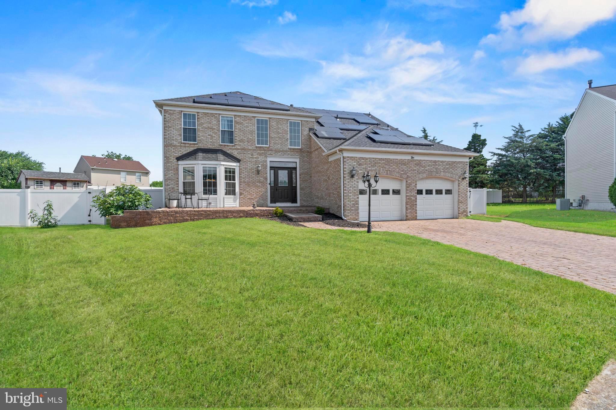 a view of a house with a big yard and large trees