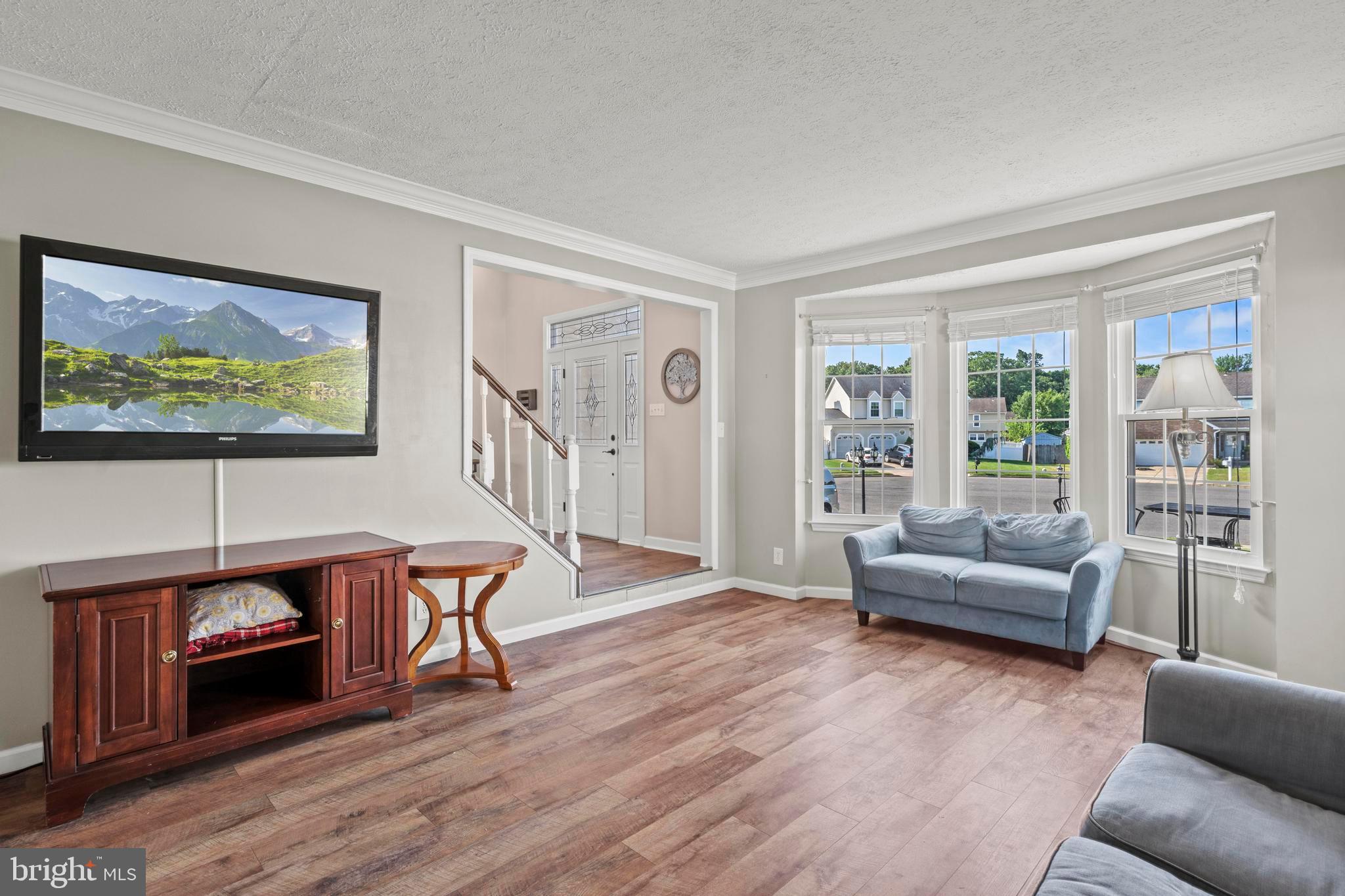 181 Aberdeen Road Williamstown, NJ 08094 - Photo 5 of 29 a living room with furniture a flat screen tv and a floor to ceiling window