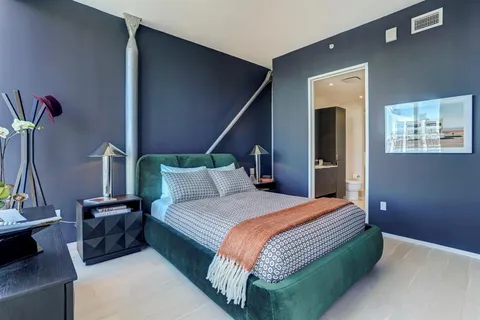 a bedroom with a bed and a potted plant