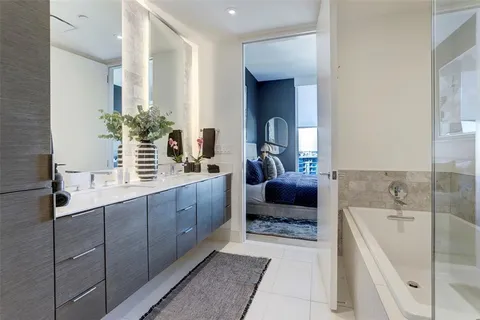 a spacious bathroom with a tub sink and mirror