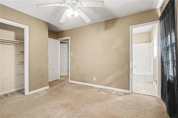 an empty room with closet and a chandelier fan
