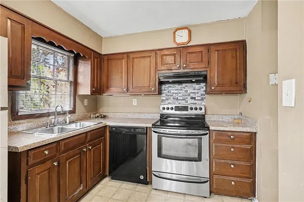 a kitchen with stainless steel appliances granite countertop a stove a sink and a microwave