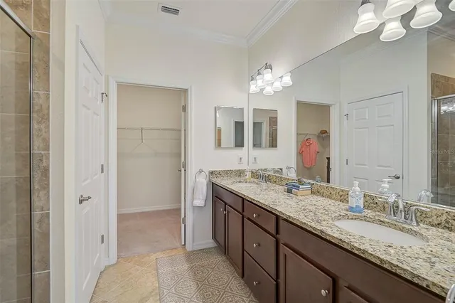 a bathroom with a granite countertop double vanity sink and a mirror