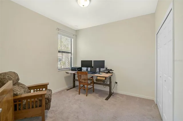 a view of a workspace with furniture and a window