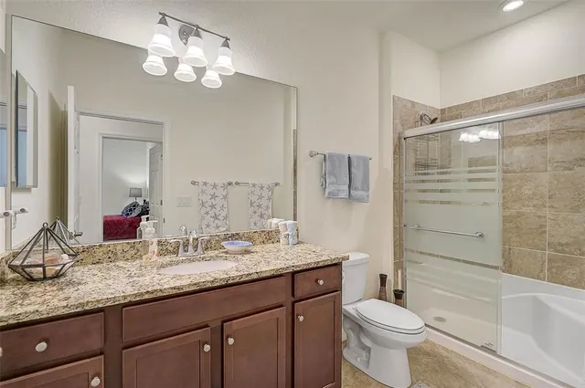 a bathroom with a granite countertop sink toilet and shower
