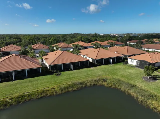 an aerial view of residential houses with outdoor space and trees