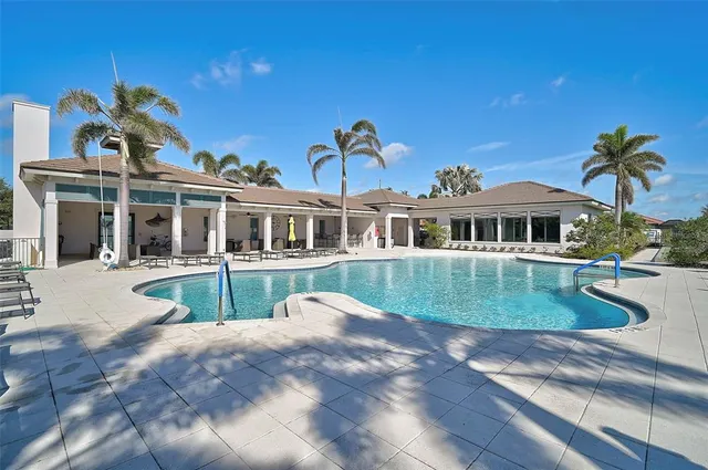 a view of a house with pool fire pit tables and chairs