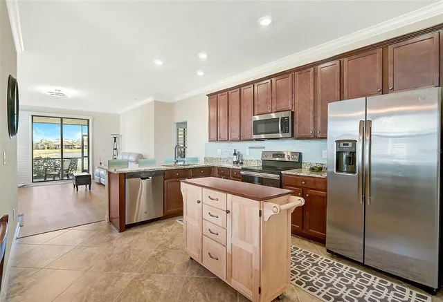 a kitchen with stainless steel appliances granite countertop a refrigerator sink and stove