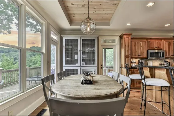 a dining room with furniture a chandelier and wooden floor
