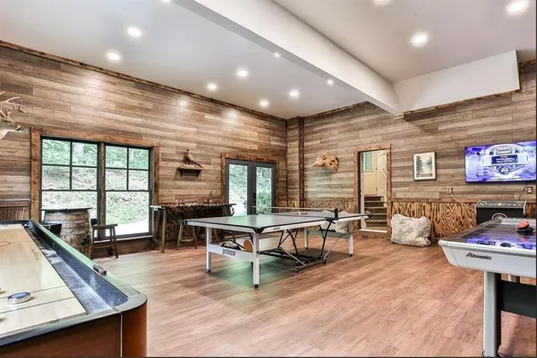 a living room with furniture a flat screen tv and a large window