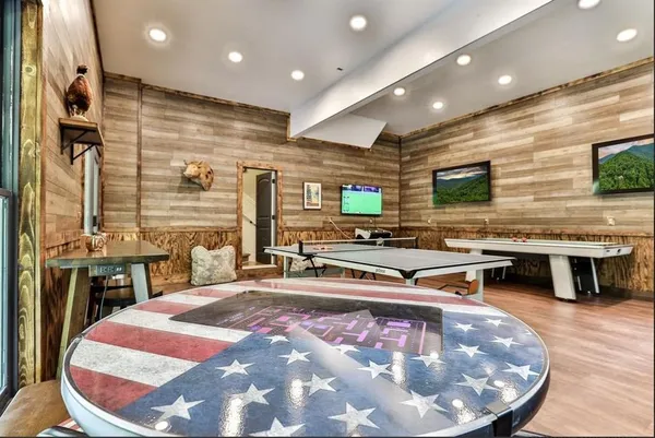 a room with table tennis pool table and chairs in it