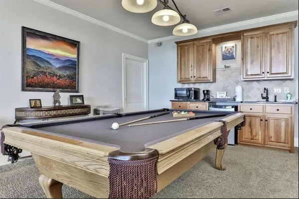 a room with furniture pool table and windows