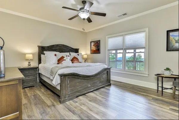 a bedroom with a bed wooden floor and a window