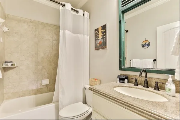 a bathroom with a granite countertop toilet sink and a mirror
