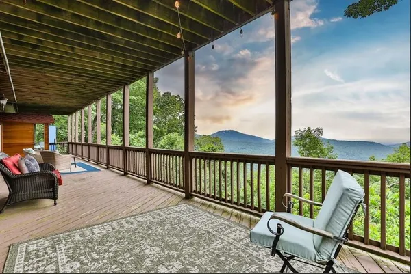 a balcony with wooden floor outdoor seating and city view