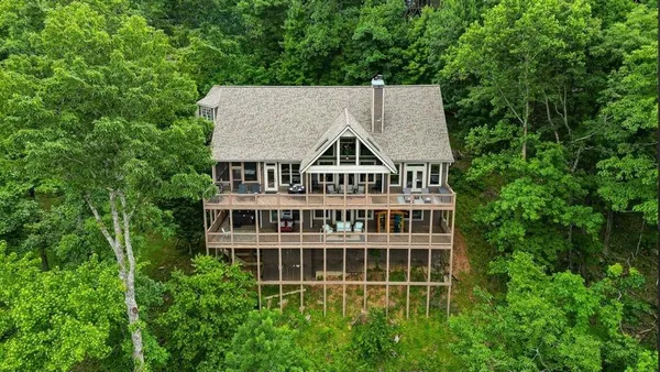 an aerial view of a house with a yard and large trees