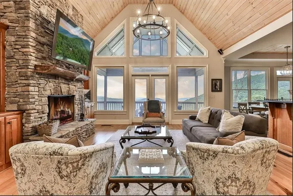a living room with furniture a fireplace and a chandelier