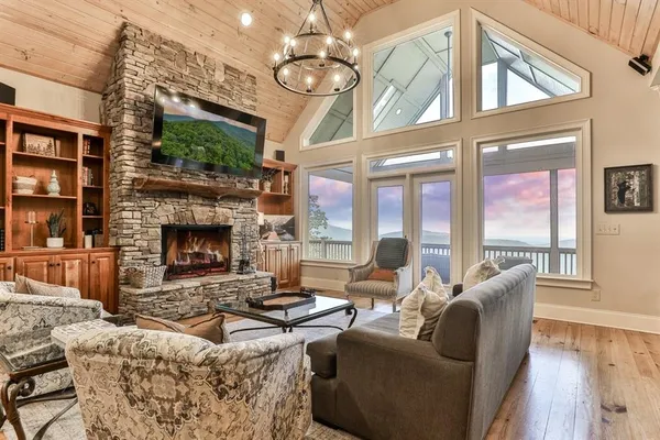 a living room with furniture a fireplace and a chandelier